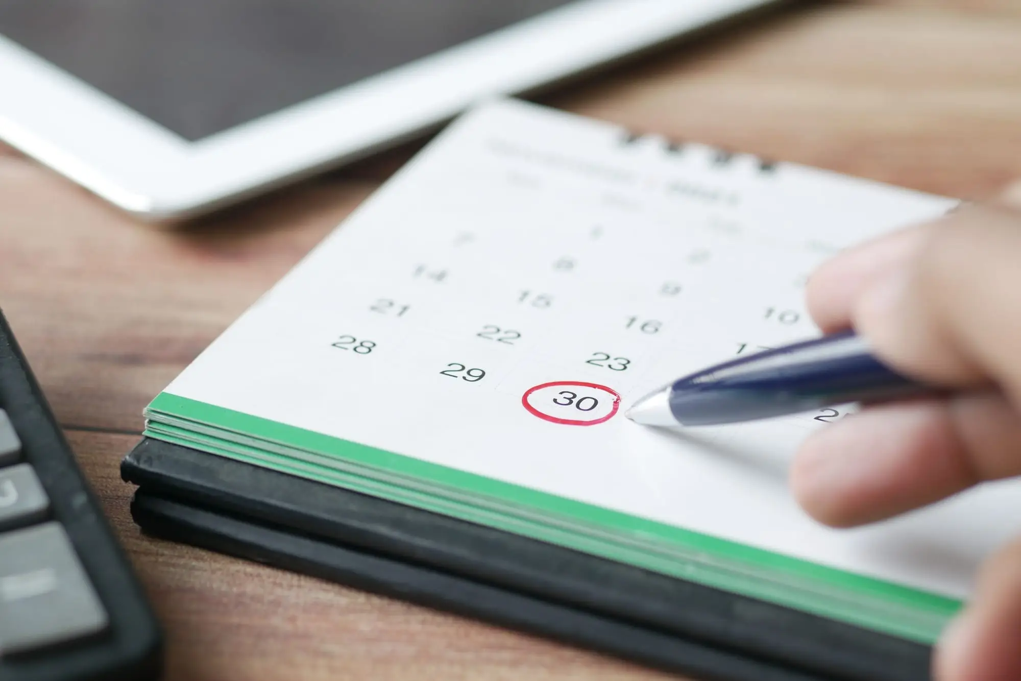Caneta marcando uma data num calendário de mesa